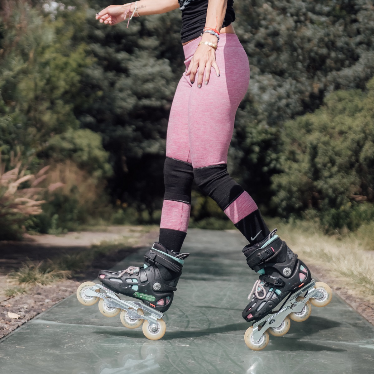 female-inline-skater-rollerblader-wearing-pink-leggings-and-knee-pads-with-rollerblades